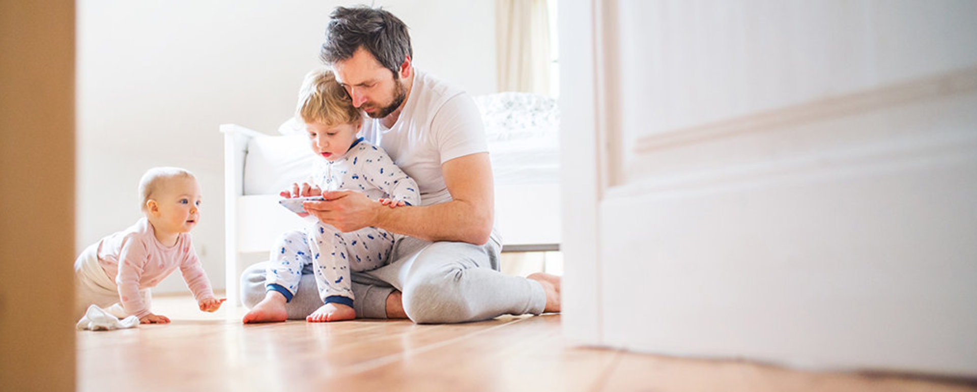 Vater mit seinen beiden Kindern informiert sich online über DITECH Fußbodenheizung