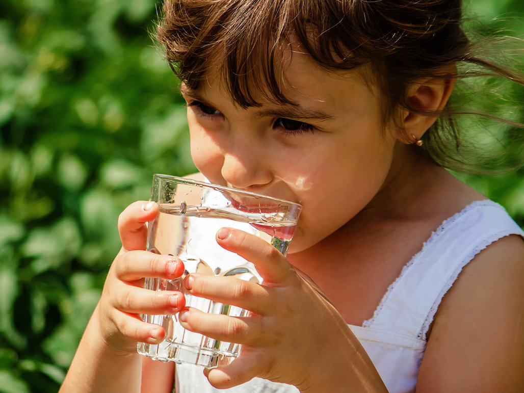 Kind trinkt aus Wasserglas