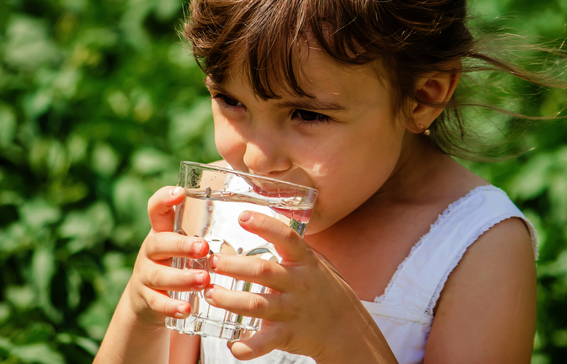 Kind trinkt aus Wasserglas